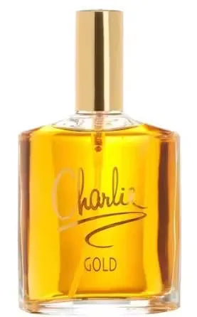 Gold bottle of Revlon Charlie Gold Eau de Toilette perfume on a mirrored vanity with sparkling lights.