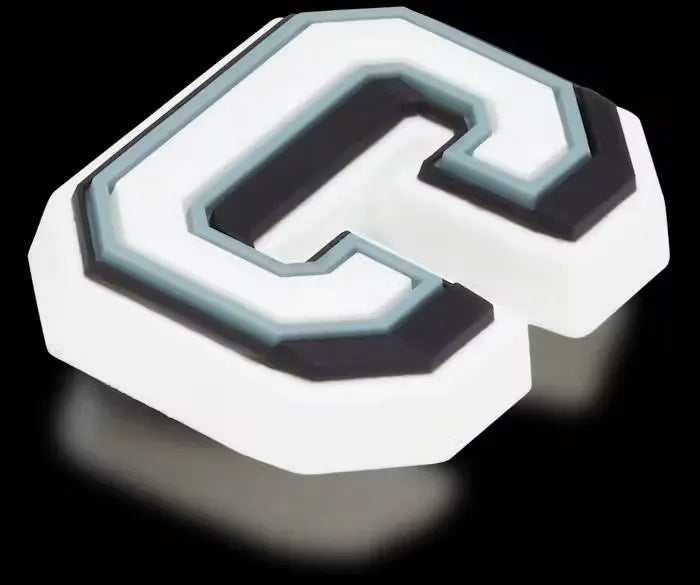 Glowing letter C charm for Crocs, shaped like the letter C and illuminating in the dark. Attached to a white background.