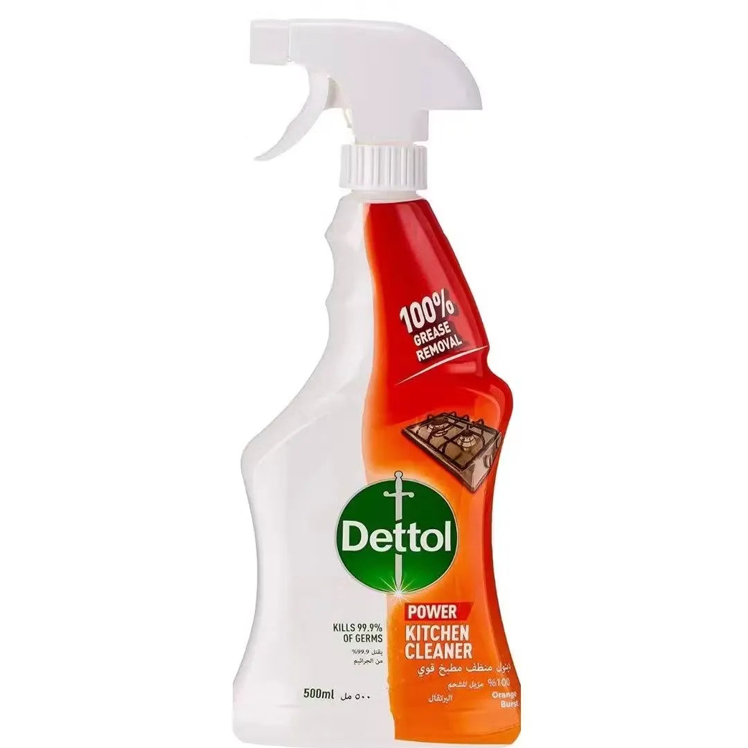 Close-up photo of Dettol Orange Kitchen Power Cleaner Spray bottle (500ml) with orange accents and orange fruit image. Spray being dispensed towards a greasy surface.