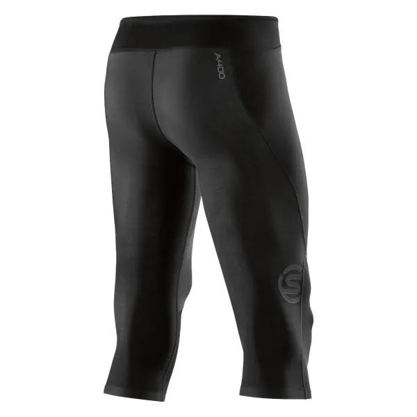 A male athlete wearing black Skins A400 3/4 compression tights, mid-stride during a workout.