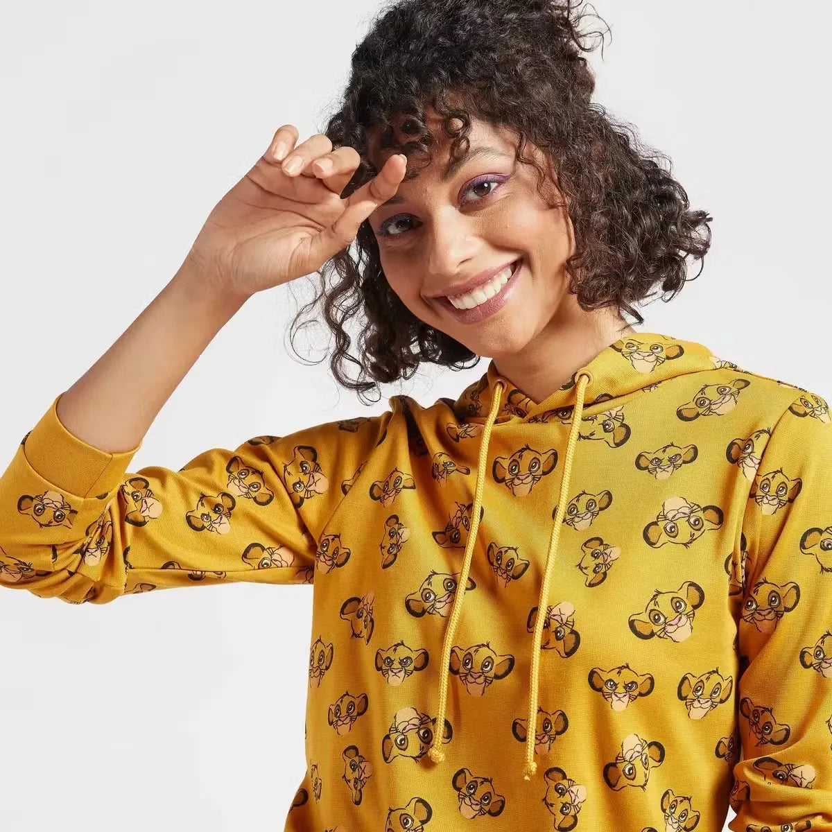 A woman wearing a hooded sweatshirt with a full-body print of The Lion King characters. Cozy up in style with the Max Lion King all-over print women's sweatshirt! Featuring a playful design and comfortable hoodie, this sweatshirt is perfect for casual wear. Shop now on Dubailisit!