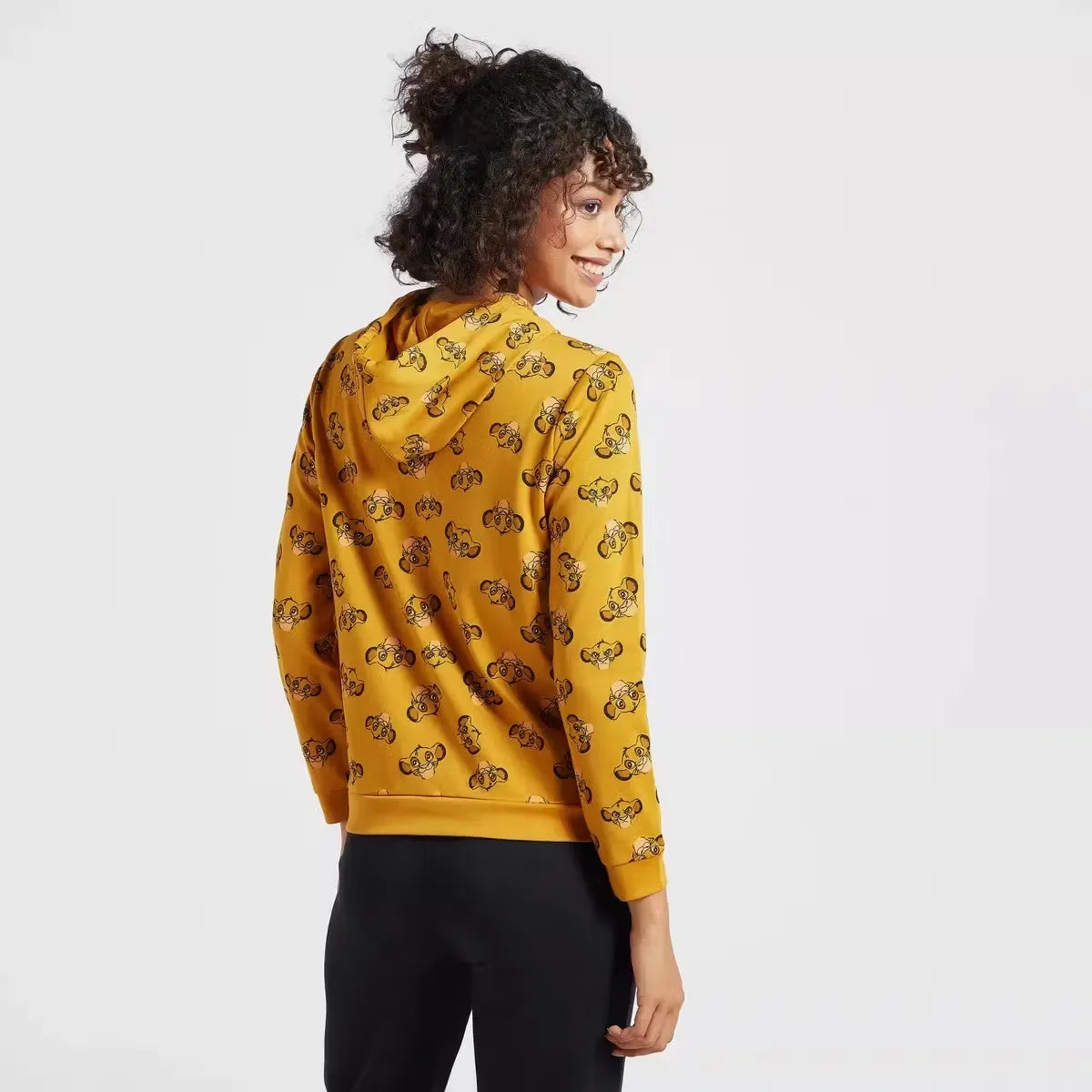 A woman wearing a hooded sweatshirt with a full-body print of The Lion King characters. Cozy up in style with the Max Lion King all-over print women's sweatshirt! Featuring a playful design and comfortable hoodie, this sweatshirt is perfect for casual wear. Shop now on Dubailisit!