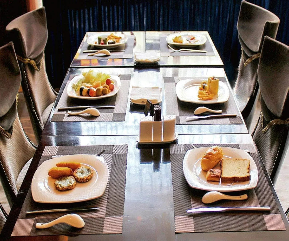 A set of six Kermeo placemats and coasters laid flat on a table. The placemats and coasters are a sleek, modern design with a non-slip texture.