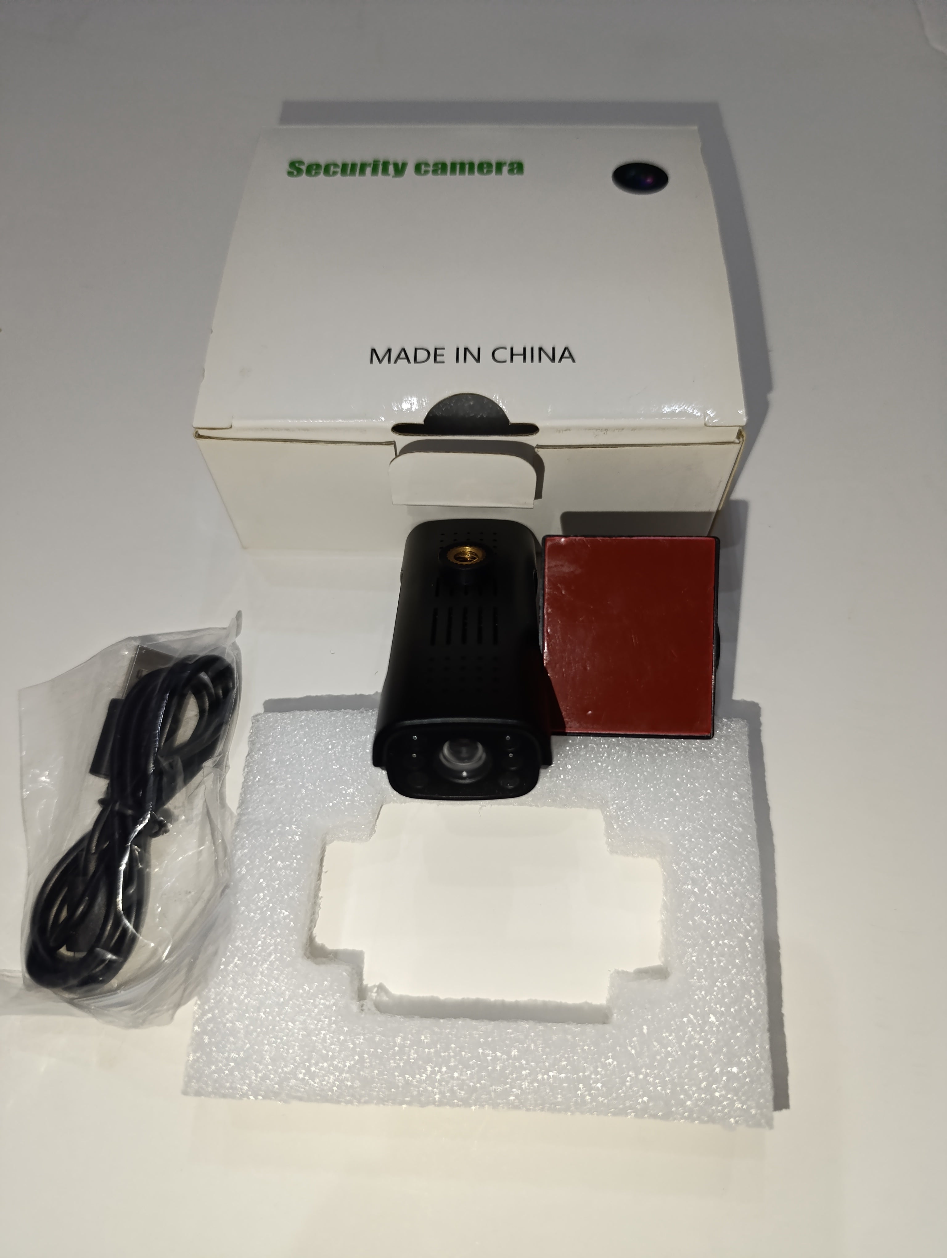 Security camera with base and charging cable