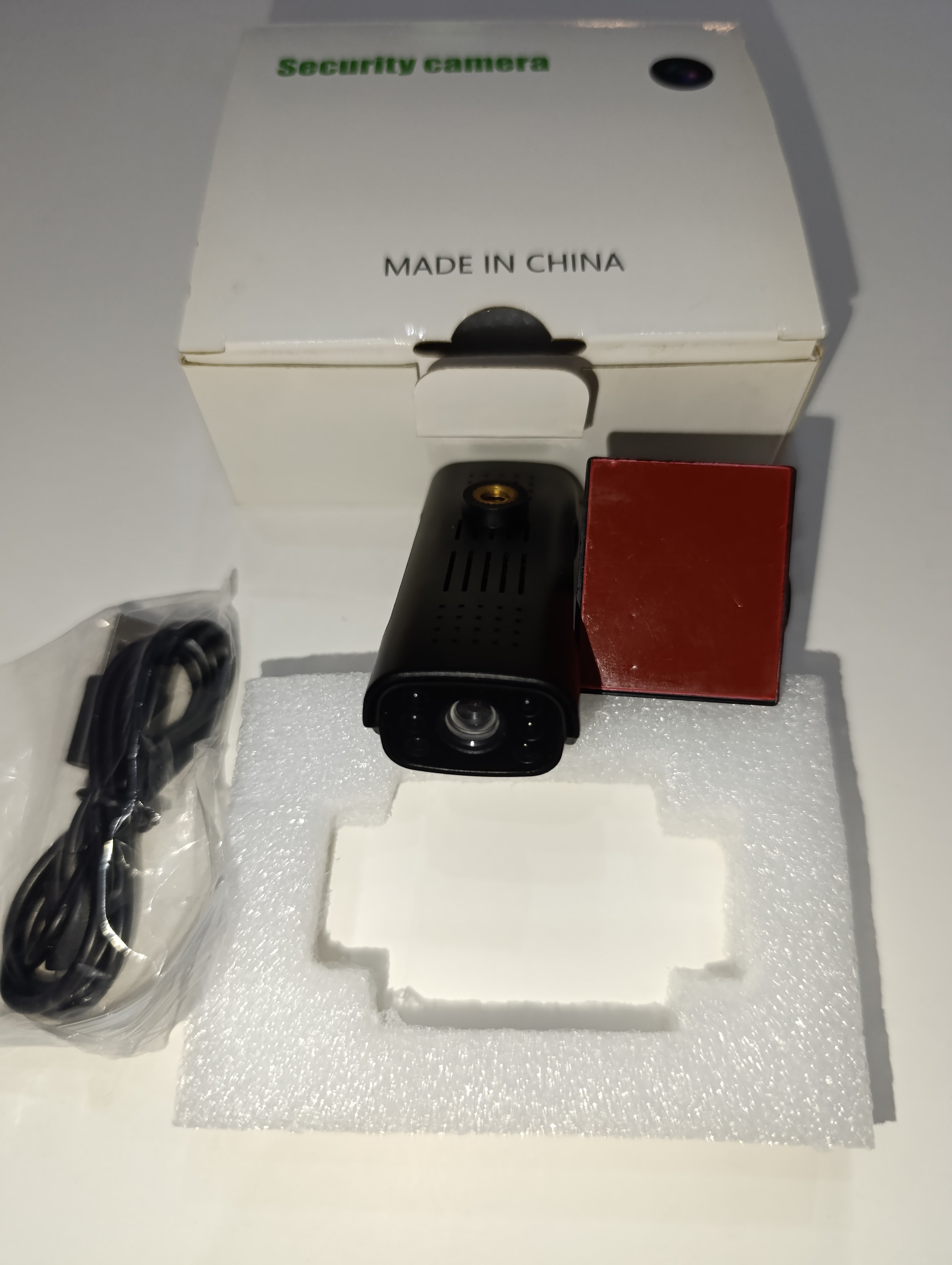 Security camera with base and charging cable