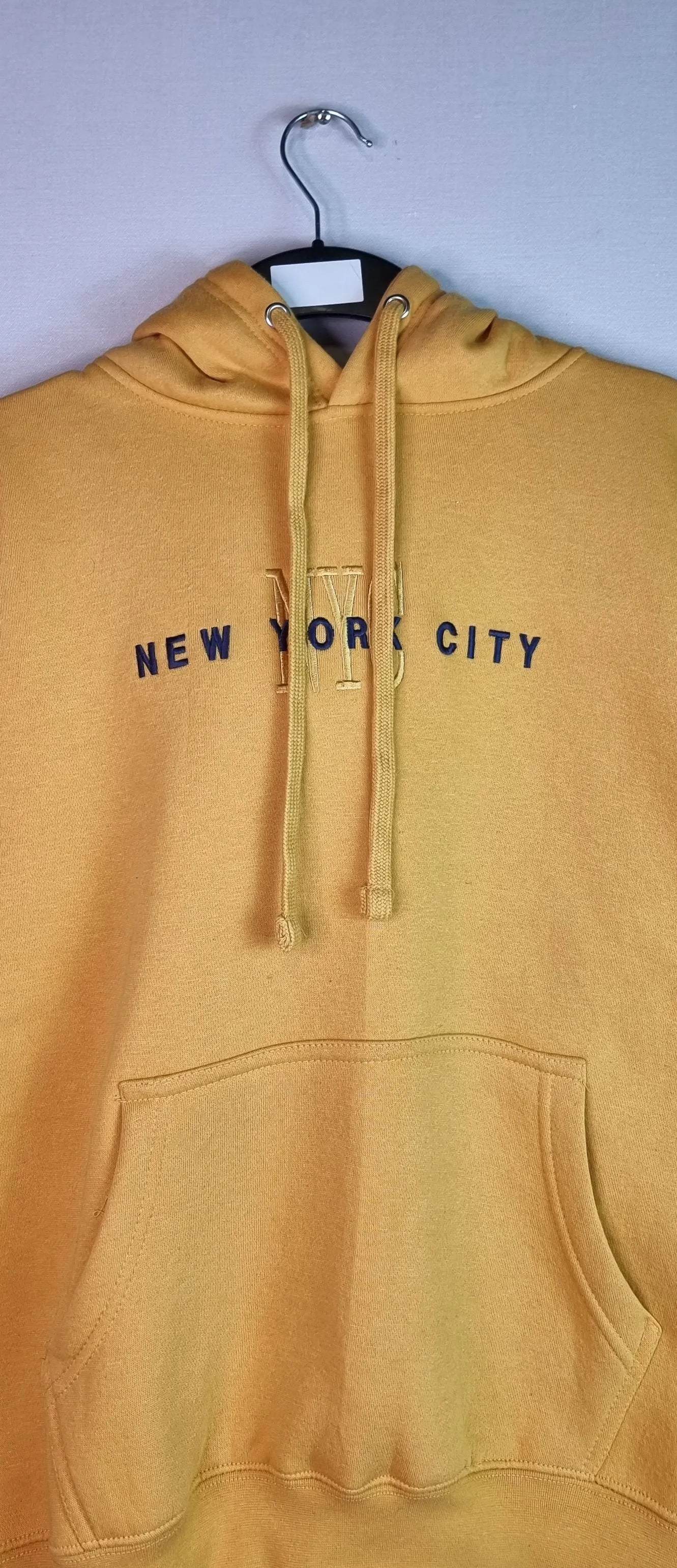  Brighten your day: Stay warm and visible in this cheerful unisex yellow hoodie from Go For It New York.Wrap yourself in the comfort of this NYC-inspired hoodie, wherever you are.