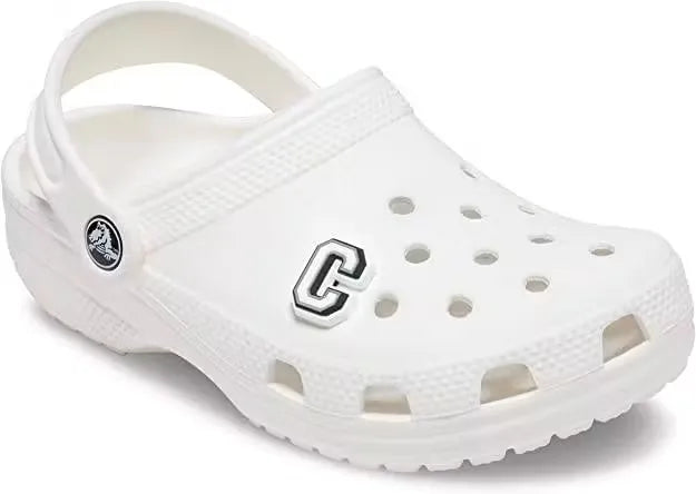 Glowing letter C charm for Crocs, shaped like the letter C and illuminating in the dark. Attached to a white background.