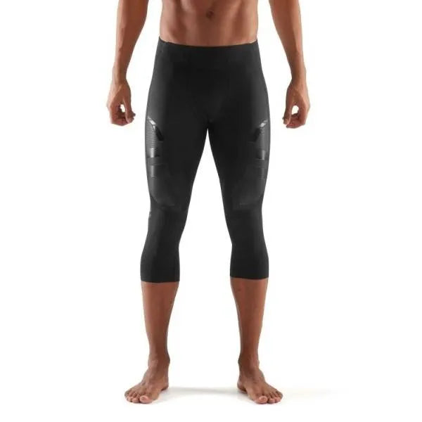 A male athlete wearing black Skins A400 3/4 compression tights, mid-stride during a workout.