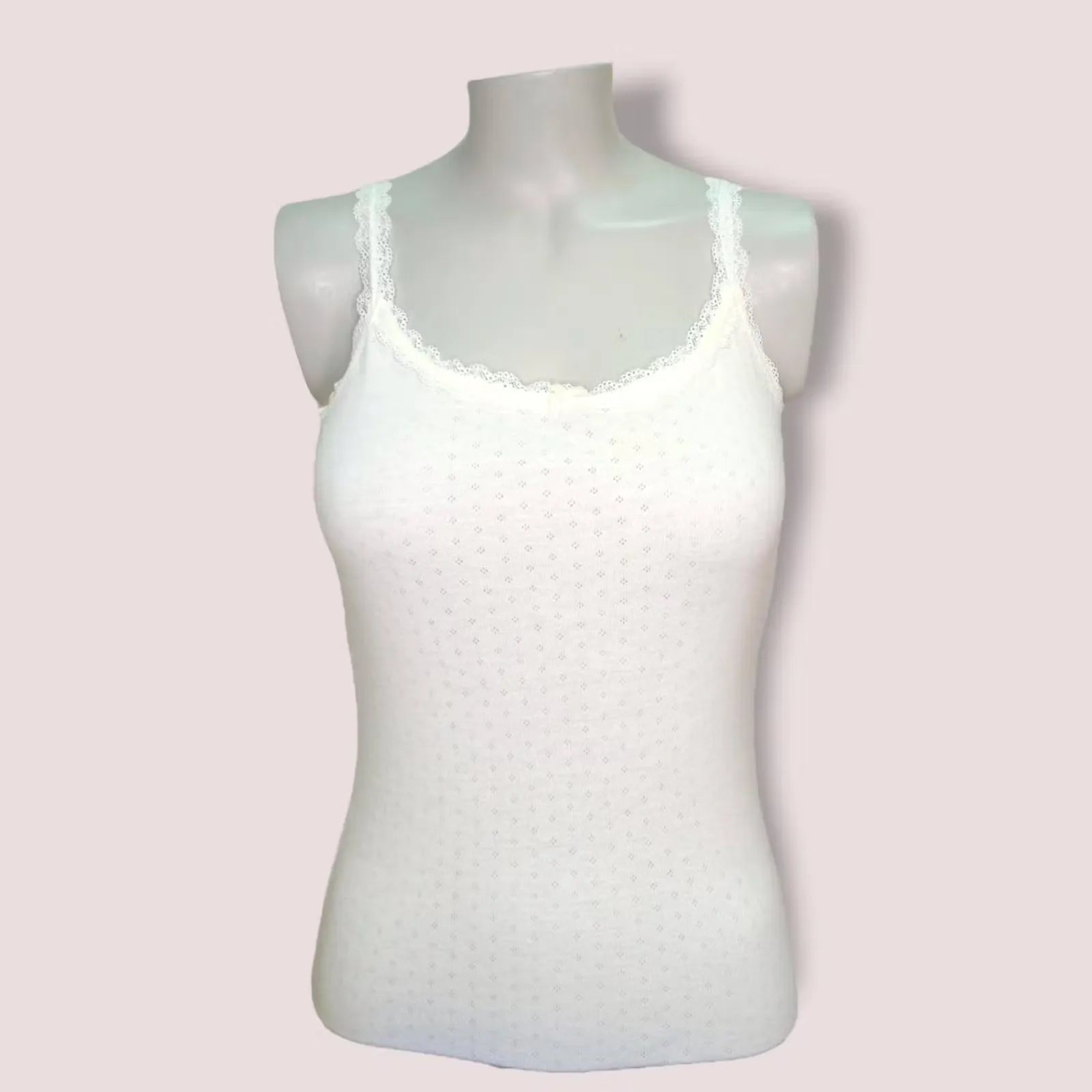A sleeveless thermal cami in a light cream color, perfect for layering or wearing alone. Made with soft and cozy fabric for ultimate comfort in winter.