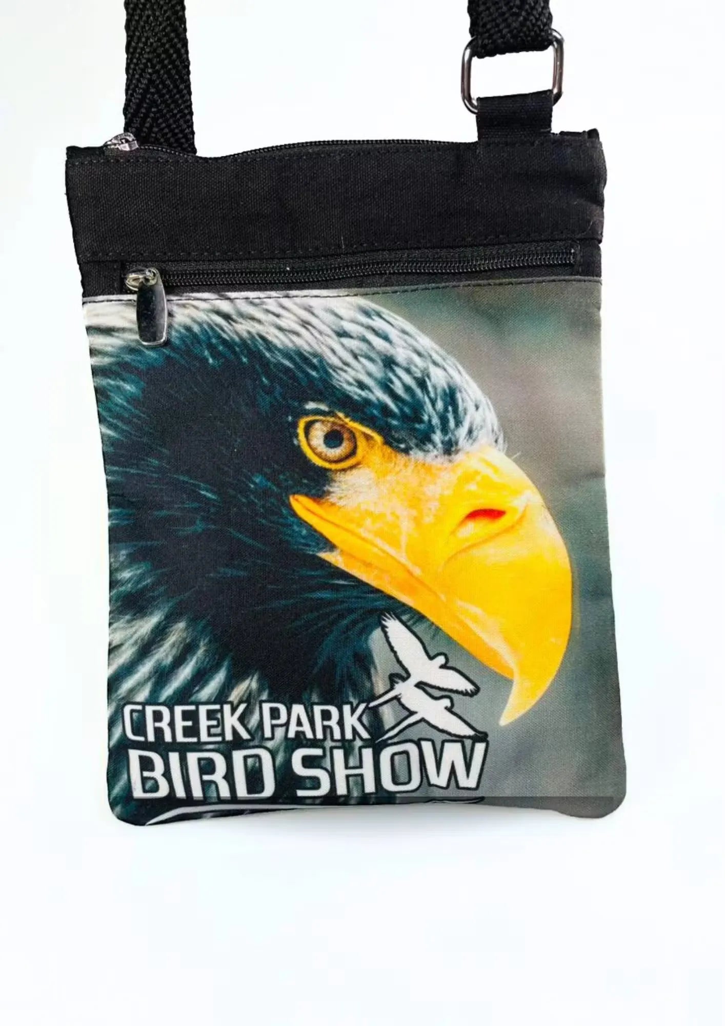 A stylish Creek Park Bird Show side bag with a black exterior and  cloths straps. The bag has multiple compartments and pockets for storing essentials.