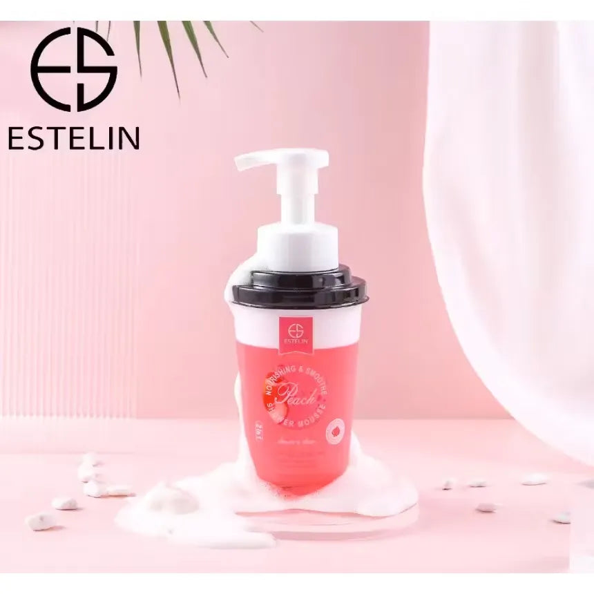 Close-up photo of Estelin Peach Shower Mousse 370ml bottle with pink accents and peach image. Creamy pink foam being dispensed onto hand.