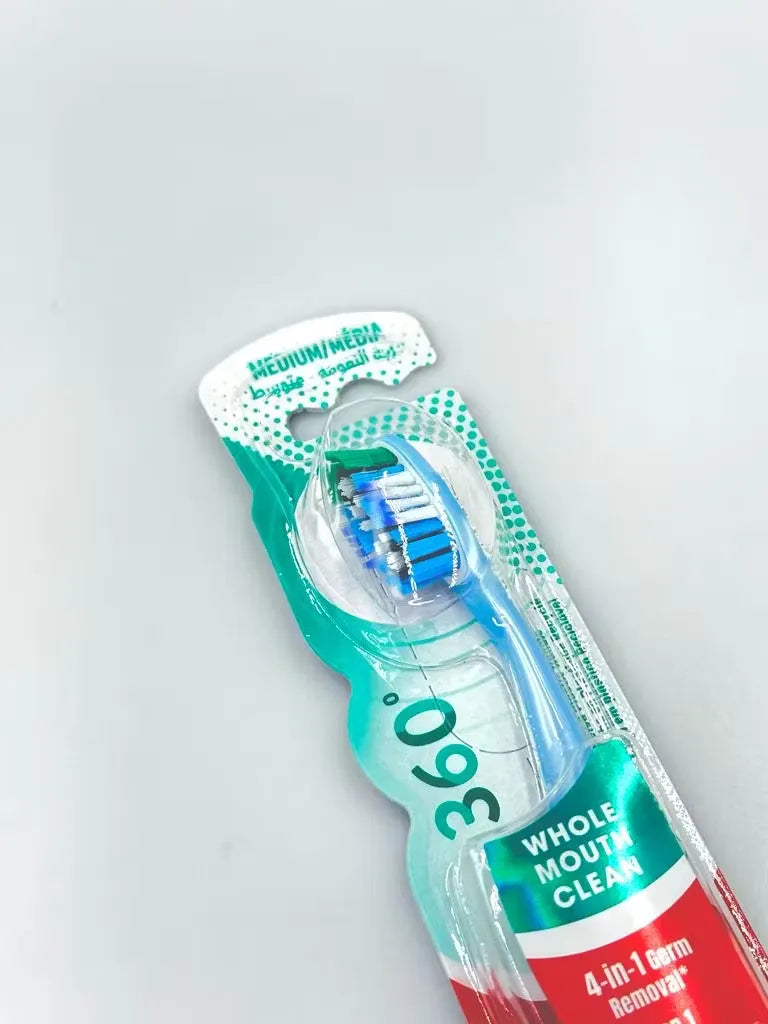 Close-up of a Colgate 360 Whole Mouth Clean toothbrush in brilliant blue, featuring medium bristles and a tongue cleaner.