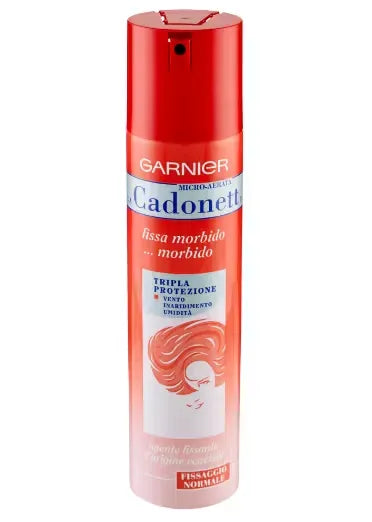 Canister of Garnier Micro-Aerated Cadonett hairspray (250ml) with a pink and silver design. A woman is using the spray to style her hair, with a focus on the flexible hold it offers.