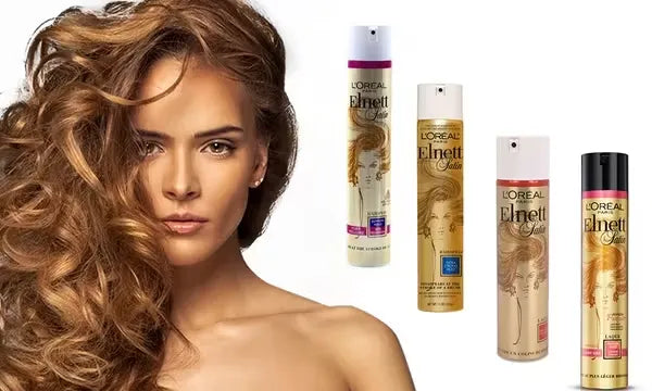 Silver can of L'Oreal Paris Elnett Micro Hairspray (250ml) with a pink nozzle and the text "Normal Hold with Precision Mist." A hand is spraying the hairspray onto styled hair.