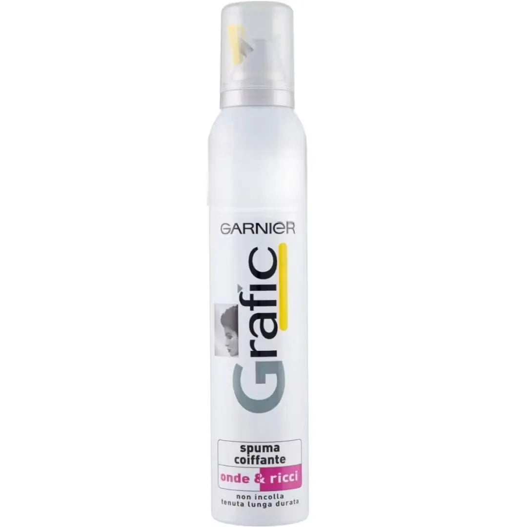 A white can of Garnier Grafic Styling Mousse (200ml) with a pump dispenser, positioned against a backdrop of styled, wavy hair.