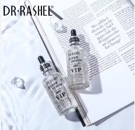 Close-up of a silver bottle with blue label and dropper dispenser, labeled "Dr. Rashel Silver Serum 99.99% Pure Silver VIP All-In-One Skincare - 50ml." Droplets of serum falling onto a person's hand.