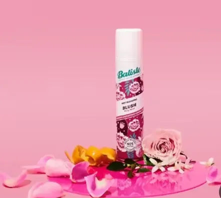 Pink and white can of Batiste Dry Shampoo in Blush fragrance (200ml) held in a woman's hand.