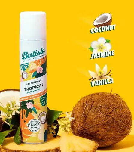 Canister of Batiste Dry Shampoo (200ml) in tropical design with a palm tree and coconut. A puff of powder is dispersing from the nozzle.