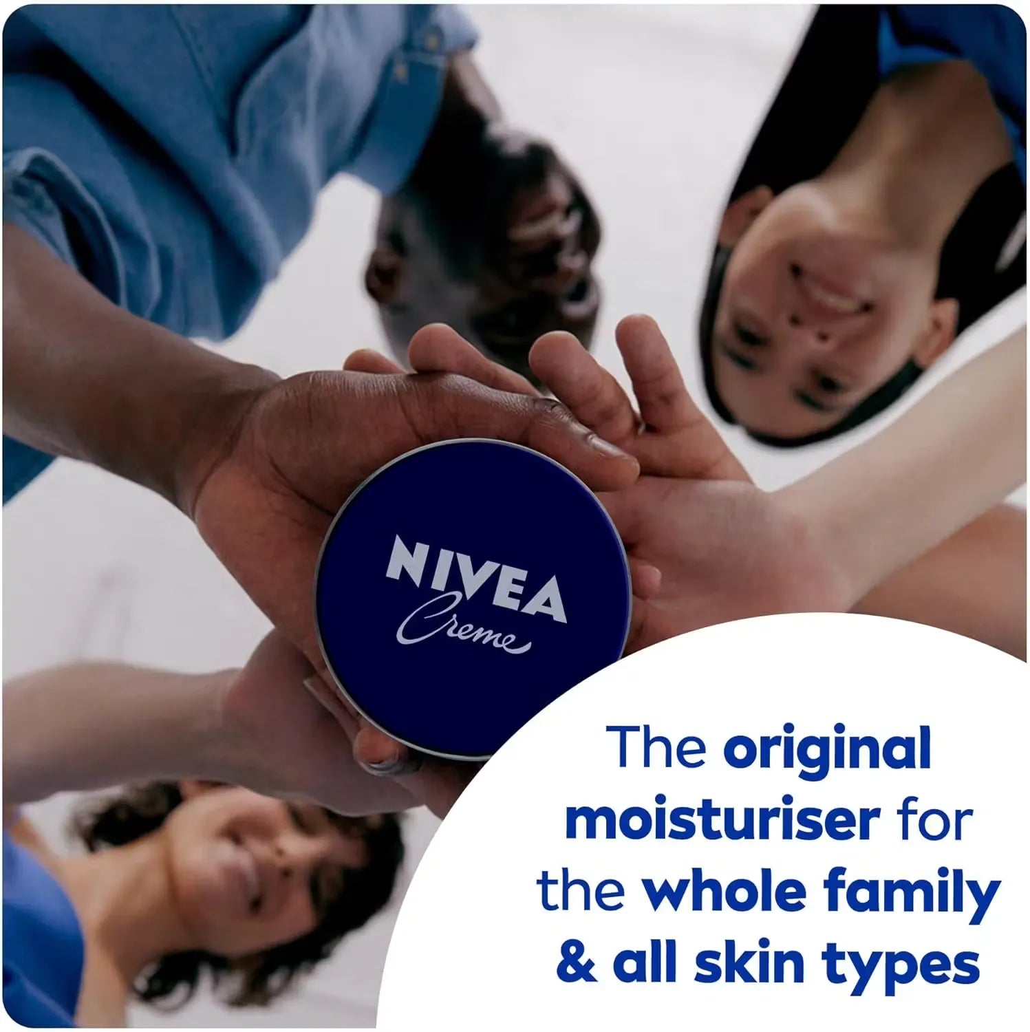 Close-up of a classic blue Nivea Creme tin (250ml) with a woman's hand opening it, revealing the creamy white moisturizer inside.