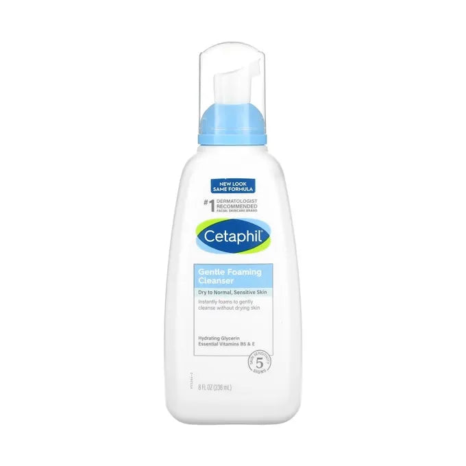 Close-up photo of a white Cetaphil Gentle Foaming Cleanser bottle with blue pump and label. Gentle foam being dispensed onto hand.