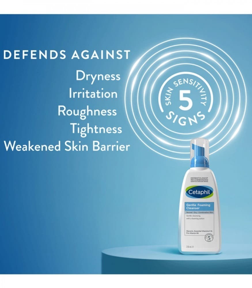 Close-up photo of a white Cetaphil Gentle Foaming Cleanser bottle with blue pump and label. Gentle foam being dispensed onto hand.