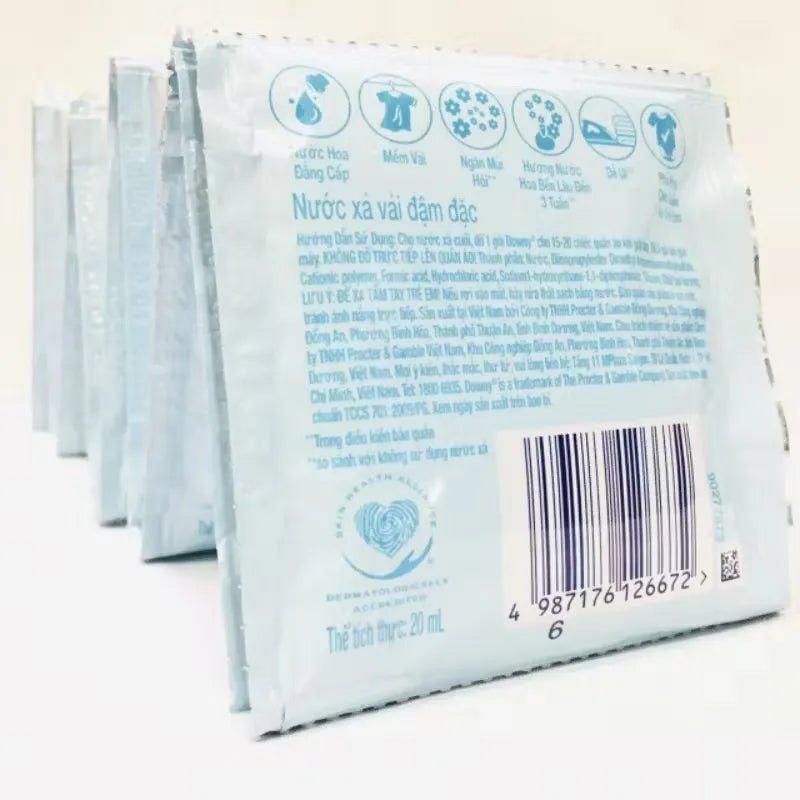 Box of Downy Premium Parfume sachets (10 x 20ml), featuring a luxurious design and scent description. Close-up of one sachet being opened, releasing a fragrant burst.