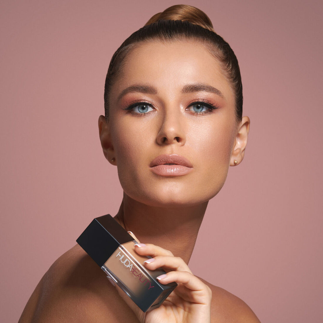 Huda Beauty #FauxFilter Foundation Latte 300N - model holding the bottle