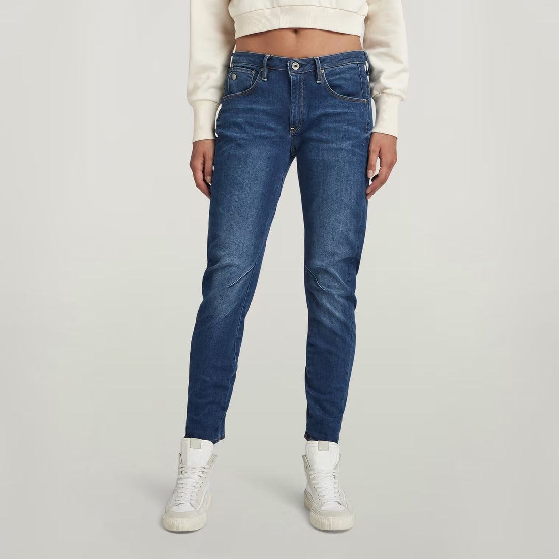 Lifestyle shot of dark blue boyfriend jeans featuring a low waist and slim fit.