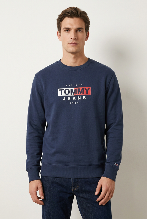 Male model wearing the navy Tommy Jeans Sweatshirt 1985
