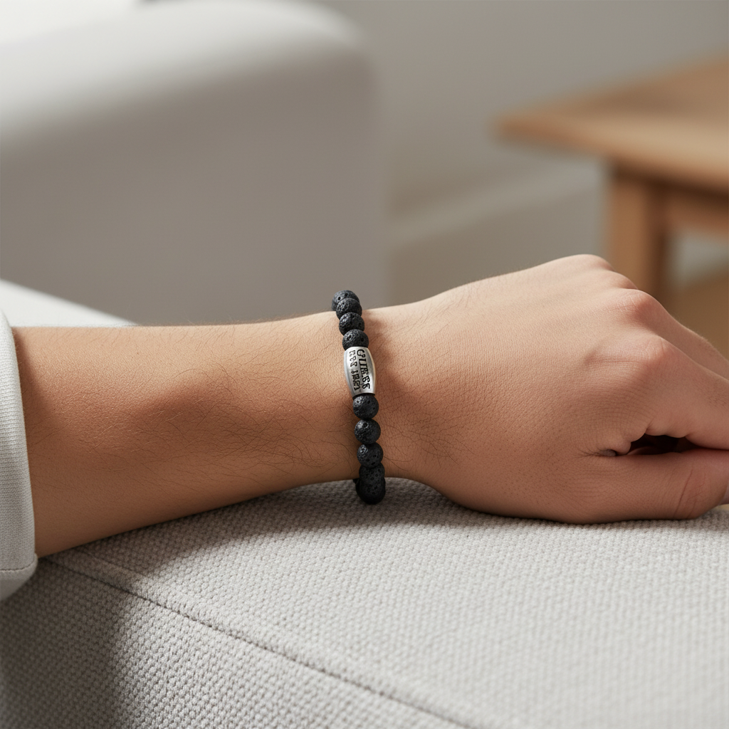 Man's wrist wearing GUESS lava stone bracelet