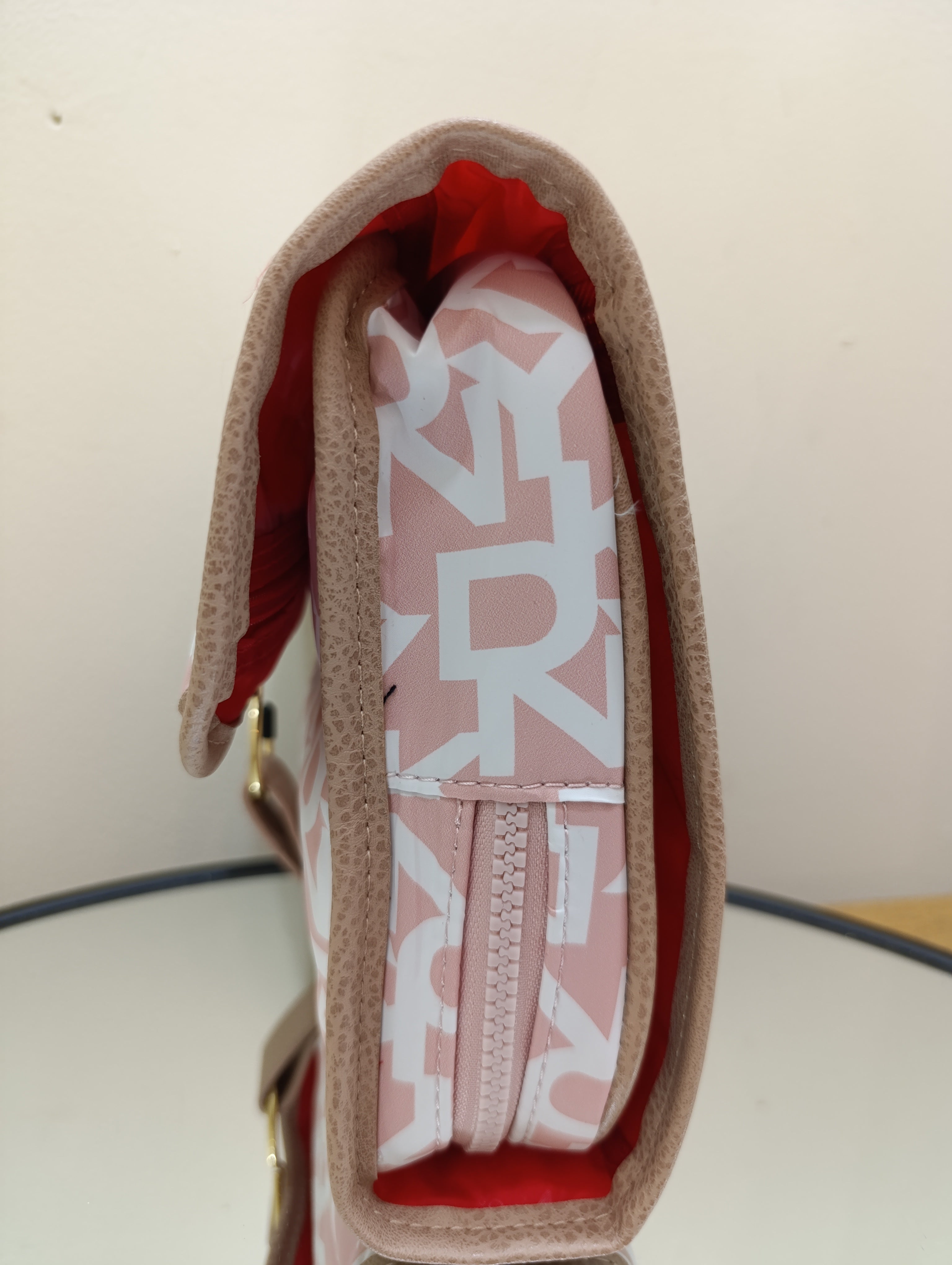 DKNY puffer roll cosmetic bag with a monogram print and tan -White light toffee
