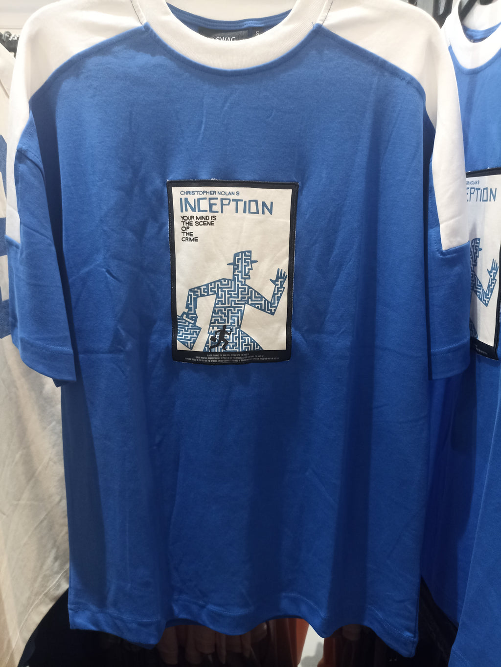 Blue and white T-shirt featuring the movie "Inception" graphic.